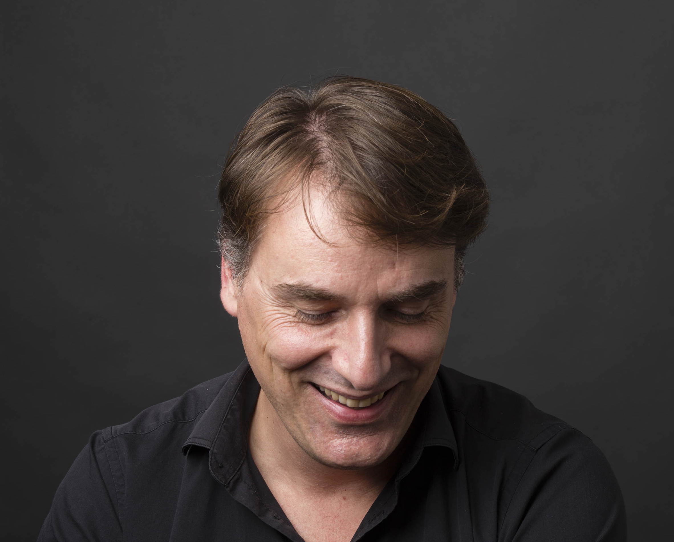 man with quiff and brown tinted sunglasses wearing a fur collar