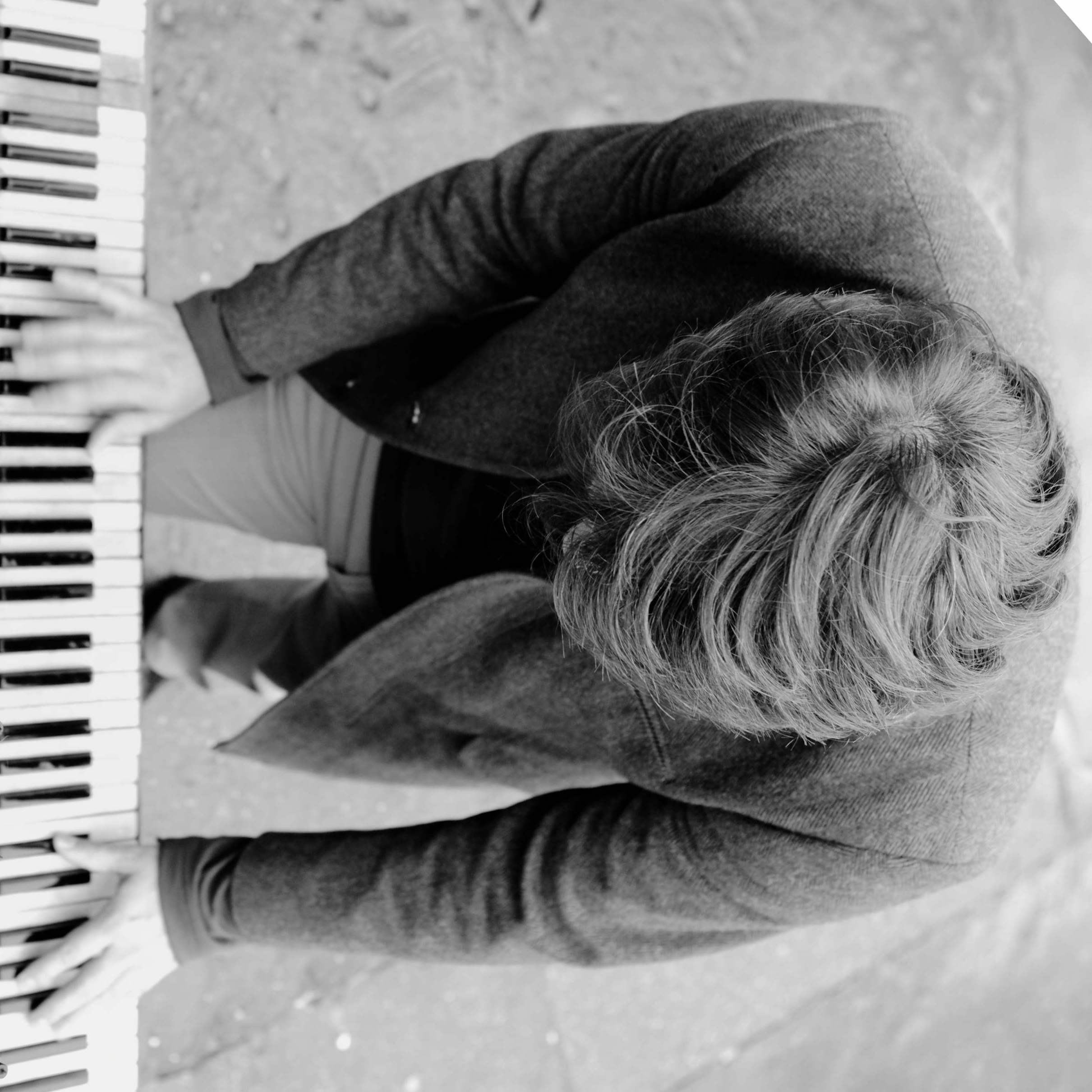 barber using styling spray on young man with black hair, short on sides and long in a quiff on top